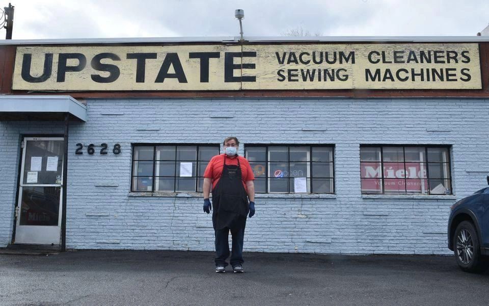 Upstate Vacuum Cleaners & Sewing Machines storefront at 2628 Erie Boulevard East, Syracuse — hand-painted sign above the shop